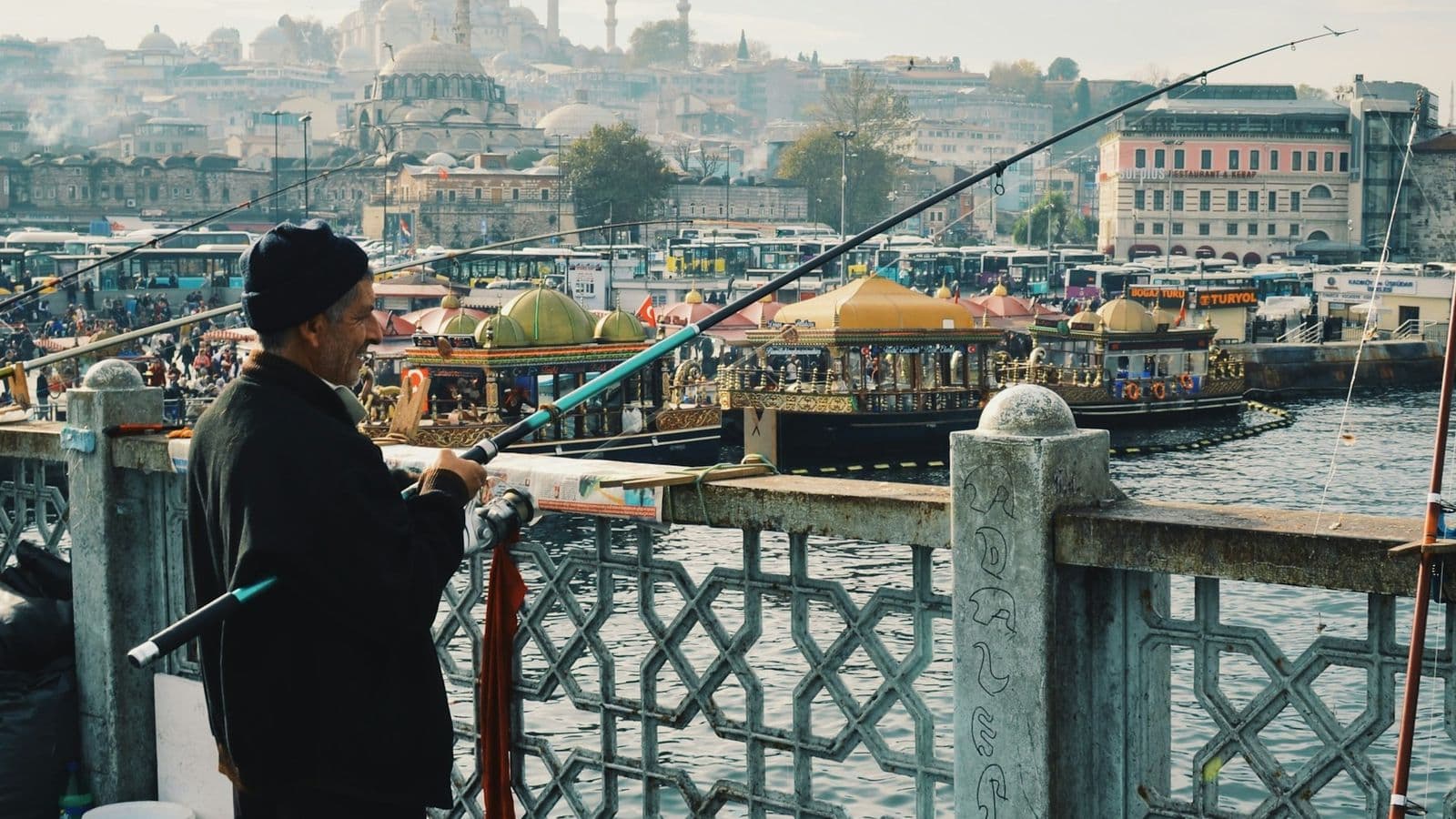 Galata Köprüsü'nde korkuluk başında olta tutan balıkçı